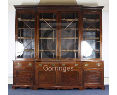 An Edwardian George III style mahogany breakfront library bookcase, with dentil cornice, blind fret carved frieze and four gl