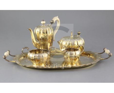 A George V silver gilt three piece coffee set and matching two handled oval tray, with later matched teapot, with engraved de