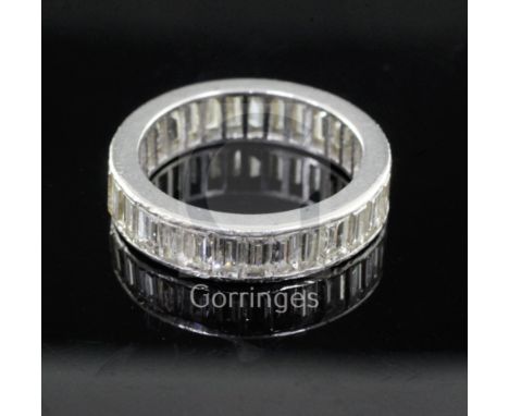 A mid 20th century platinum? and baguette cut diamond full eternity ring, set with thirty one diamonds, size M/N.