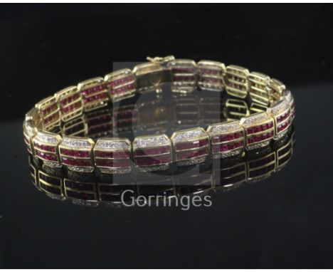 A modern 18ct yellow gold, ruby and diamond line bracelet, with two rows of channel set rubies flanked by claw-set diamonds, 