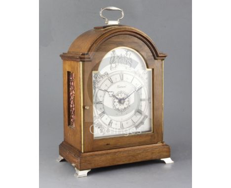 A silver mounted mahogany quarter chiming table clock, by J.W. Elliott Ltd for Garrard, the break arch case with applied hall