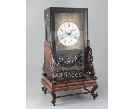 A 19th century Chinese hardwood mantel clock, of characteristic design, the pierced and carved stand raised on a turntable ba