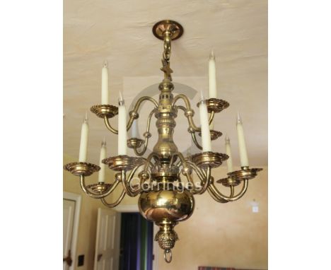A late 19th century Dutch brass twelve light chandelier, with ball and baluster stem supporting two tiers of branches ending 