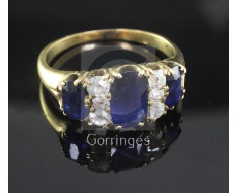 A gold, three stone sapphire and six stone diamond half hoop ring, set with oval sapphires and round cut diamonds, size Q/R.