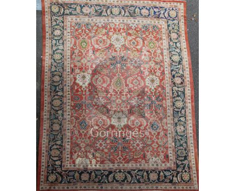 A Ziegler carpet, the madder field with a trellis bearing ivory flowerheads, floral sprays and vines, with rosette, vine and 