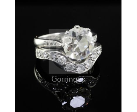 A modern platinum and diamond wedding set comprising a single stone diamond ring and eleven stone diamond set shaped band, th