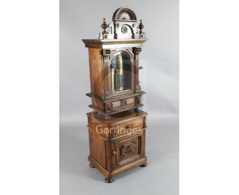 A late 19th century German upright symphonium, the walnut case of architectural form with drawer concealed in the base, opera