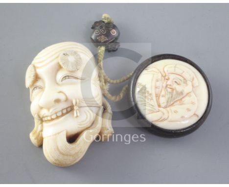 A Japanese ivory noh mask netsuke and an erotic manju ivory and wood netsuke, late 19th / early 20th century, both unsigned, 