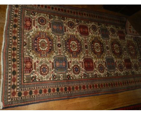 A Causcasian red and ivory ground carpet, the field with elephant pad motifs, multi-bordered and fringed. L: 266 cm W:162 cm 