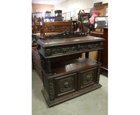 Victorian Dark Oak Buffet, profusely carved including Green Man Masks, comprising two drawers over a shelf above two cupboard