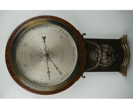 An early 20th century oak cased barometer with lion mask decoration. 