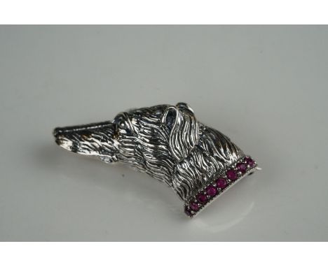 Unusual silver dog brooch, on ruby platform 