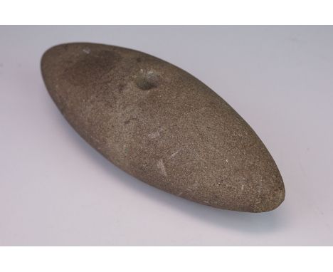 A carved stone tool head, possibly Native American. 