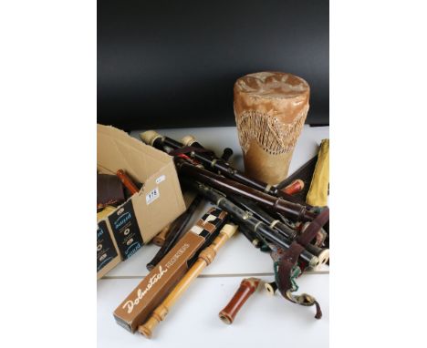 A large collection of recorders together with a drum and a flute. 