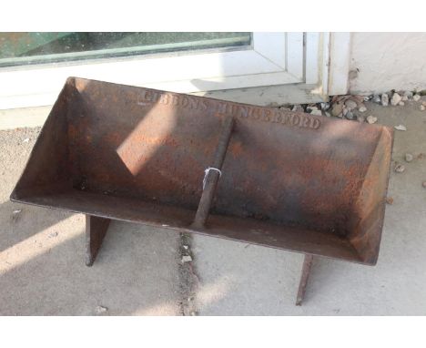 A vintage cast iron food trough marked Gibbons, Hungerford. 