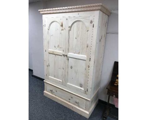 A light pine double door wardrobe fitted with a drawer, width 130 cm
