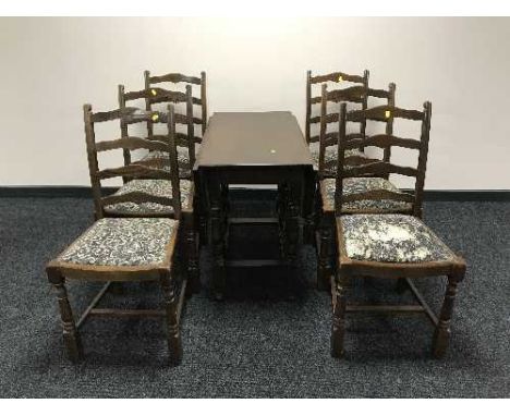 An oak drop leaf table and six oak ladder back chairs 