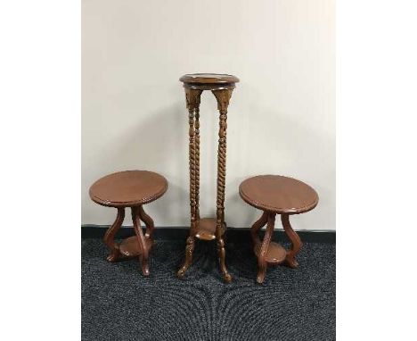 A mahogany barley twist plant stand together with a pair of circular lamp tables