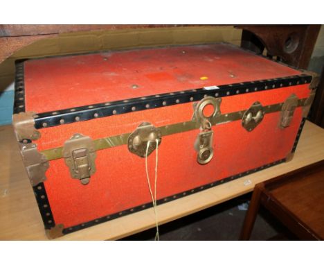 A RED TRAVEL TRUNK 