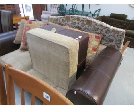 A 2 seater leather sofa, a pouffe and 4 cushions