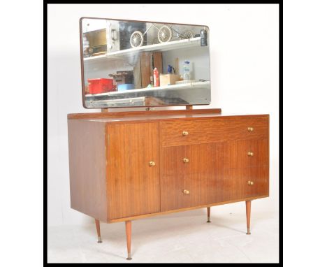 A vintage mid 20th Century teak wood dressing table having a configuration of three graduating drawers with a single cupboard
