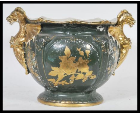 An unusual early 20th Century staffordshire ceramic planter / pot, twin handled in the form of two gilt dragons on a green gr