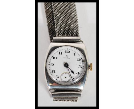 An early 20th Century Omega hallmarked silver watch having a white enamel face with bold numeral chapter ring, faceted hands 