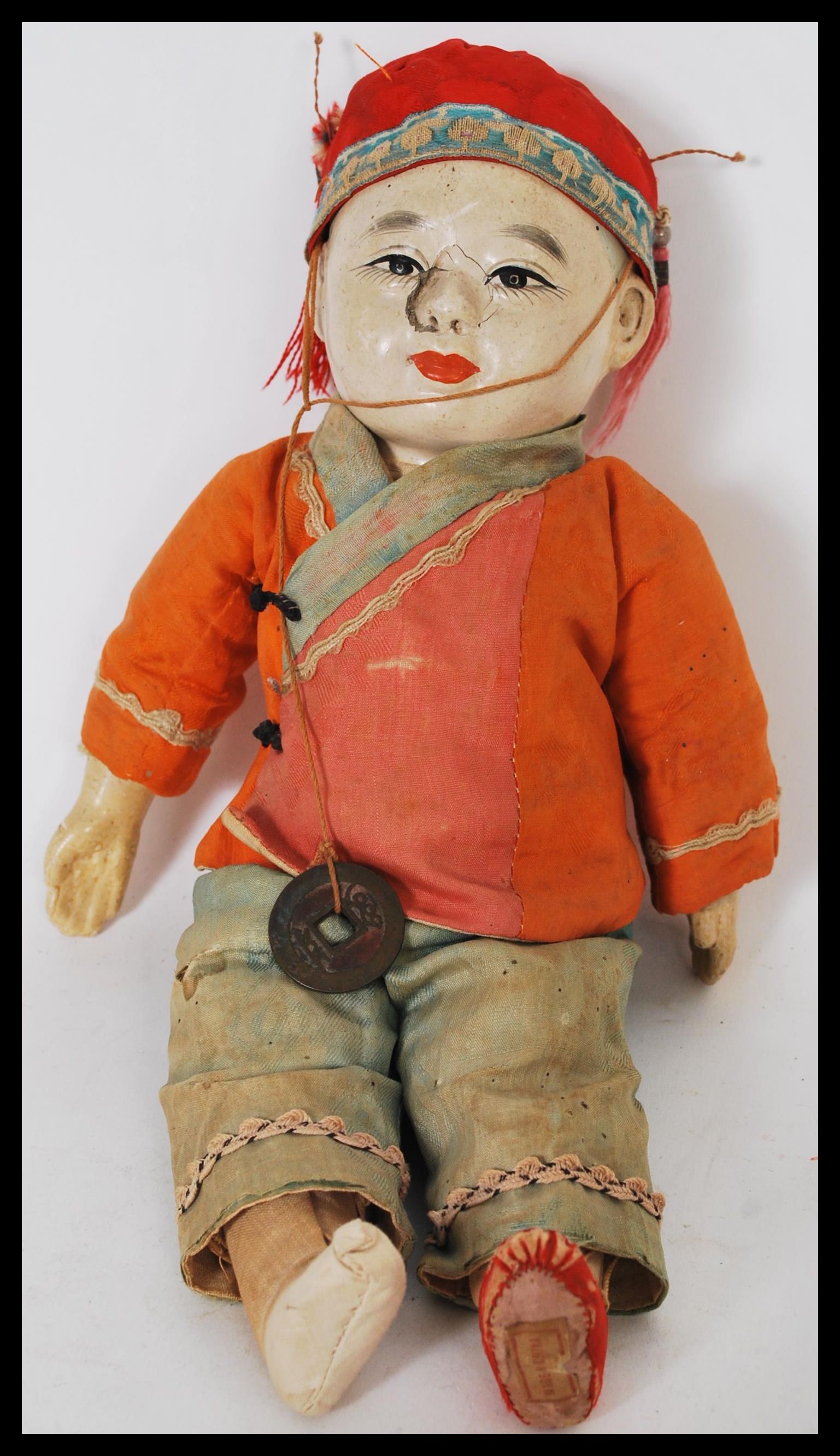 A vintage early 20th Century Chinese papiermâché and silk doll, the