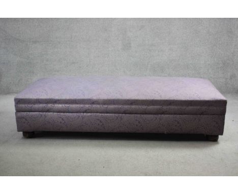 A daybed ottoman in paisley upholstery on circular supports. H.40 W.185 D.77 cm. 