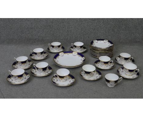 A Crown Staffordshire fine china royal blue and gold twelve person hand painted part tea set. Decorated with rose swags. Incl