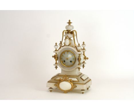 A 19th Century French alabaster and gilt metal mounted mantel clock, surmounted by vase shaped finials and beaded scrolls, ci