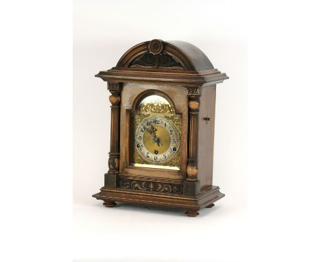 A 19th Century German carved walnut cased mantel clock, having brass spandrel dial and silvered chapter ring with Westminster