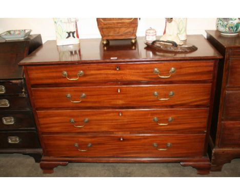A George III mahogany chest, of four long graduated drawers fitted with brass swan neck handles, raised on ogee bracket feet,