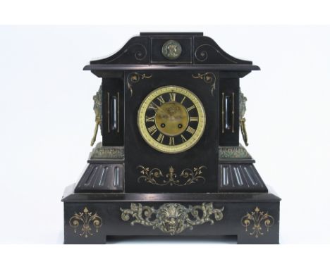 A 19th Century black marble and gilt metal mounted mantel clock, of architectural form, flanked by mask ring handles, the cir