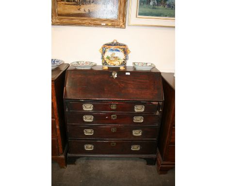 A George III  mahogany bureau, the fall front opening to reveal an interior arrangement of drawers and pigeon-holes, four lon