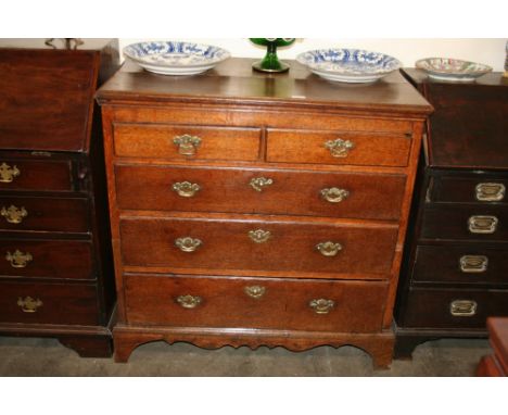 A George III oak chest, of two short and three long graduated drawers, fitted with brass drop handles and butterfly backplate