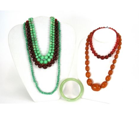 Two strings of amber beads; a set of hardstone beads; a set of jade type green graduated beads and a jade bangle, (5)
