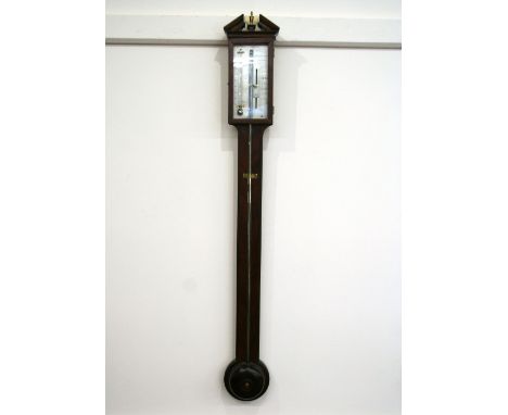 A Georgian mahogany stick barometer, by F. Sago & Co., Cirencester, having silvered dials in a feather banded case with turne