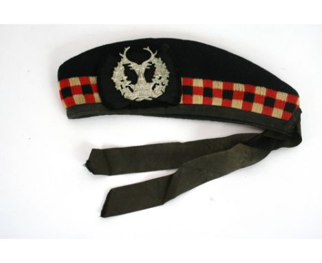 A Scottish army cloth cap, Stag's head badge, inscribed "Bydand"