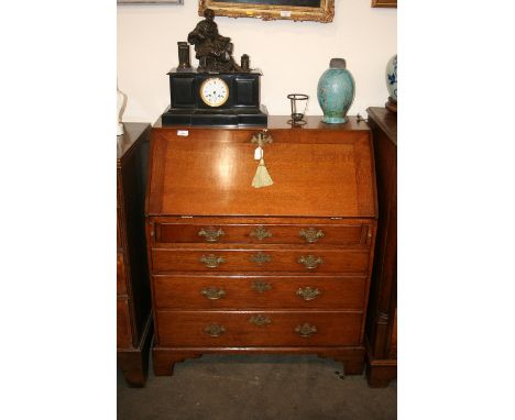 An 18th Century oak bureau, of small proportions, the fall front opening to reveal and interior arrangement of drawers, secre