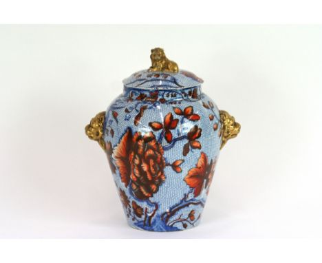 A Victorian porcelain vase and cover, having all over floral decoration on a blue ground with gilt lion mask handles and fini