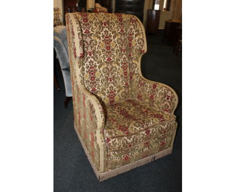 An early 20th century tapestry covered wing back armchair on castors, 61cm