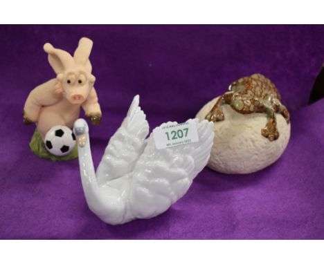 Three assorted figures including a Lladro swan, a The Potting Shed 'Gecko on a stone'  and a Piggin 'Piggin Football'.