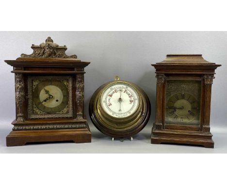 TWO EDWARDIAN OAK MANTLE CLOCK CASES, and a brass cased ship's bulkhead aneroid barometer mounted on an oak board, 28cms dia.