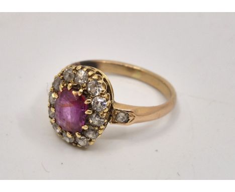 A yellow metal, natural ruby and diamond cluster ring, set cushion cut natural Burmese ruby to centre (ERW 1.1 carats), borde