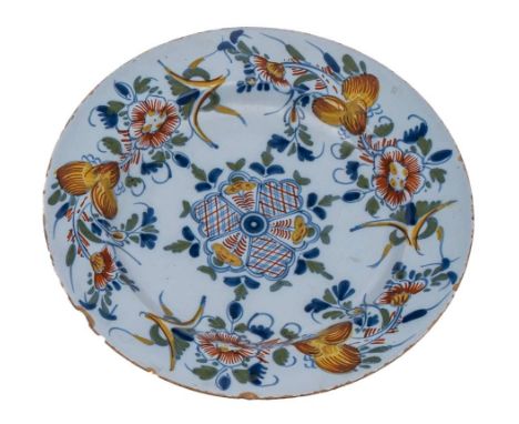 A Bristol polychrome delftware dish: painted in blue, green, yellow and ochre with floral sprays around a central fan-shaped 