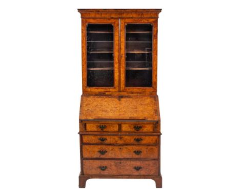 A George II burr walnut and feather banded bureau cabinet, second quarter 18th century,: the moulded cavetto cornice above tw