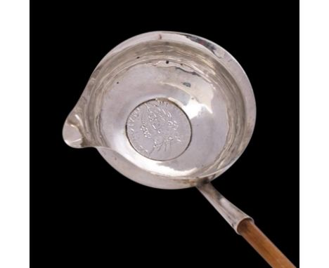A George III Silver toddy ladle, maker's mark worn, London, 1786: of traditional design with inset coin, mounted on a wood ha