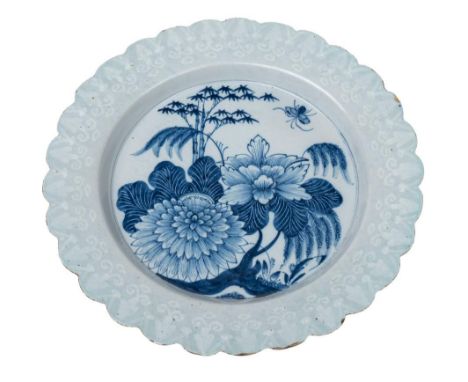 An English delftware dish: the cavetto painted in blue with peony, bamboo, willow and a butterfly within a bianco-sopra-brian