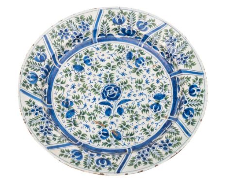 A mid 18th century delftware dish, probably Dublin: painted in blue and green with floral sprays and green foliage, painter's